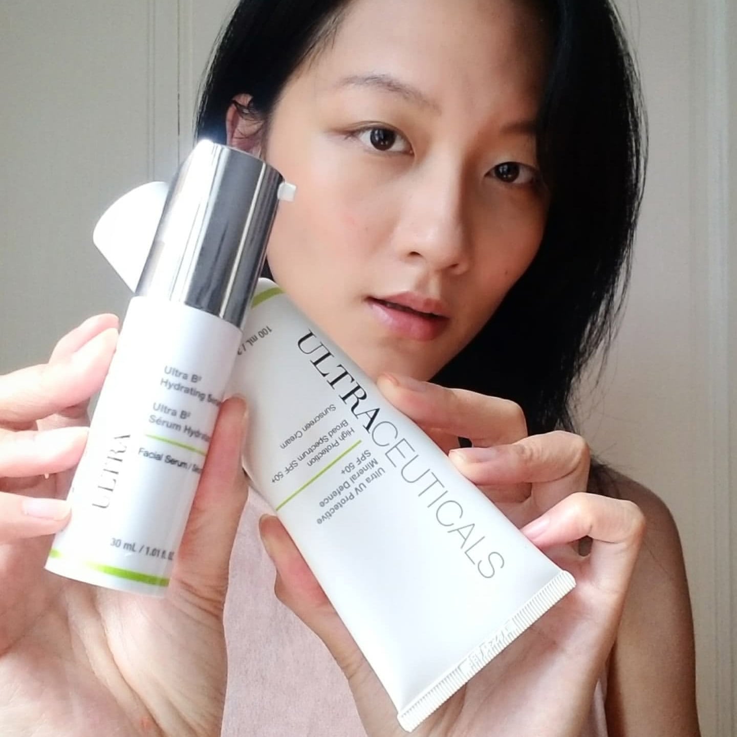 skincare influencer holding up products from ultraceuticals